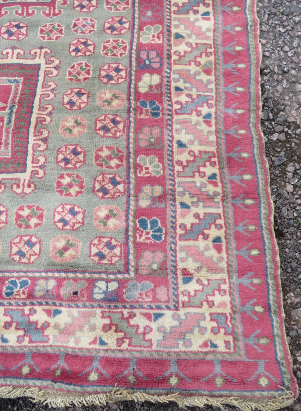 An antique Turkish Bergama wool carpet featuring a red central field surrounded by sage green areas with geometric Holbein square medallions and detailed borders. View VII