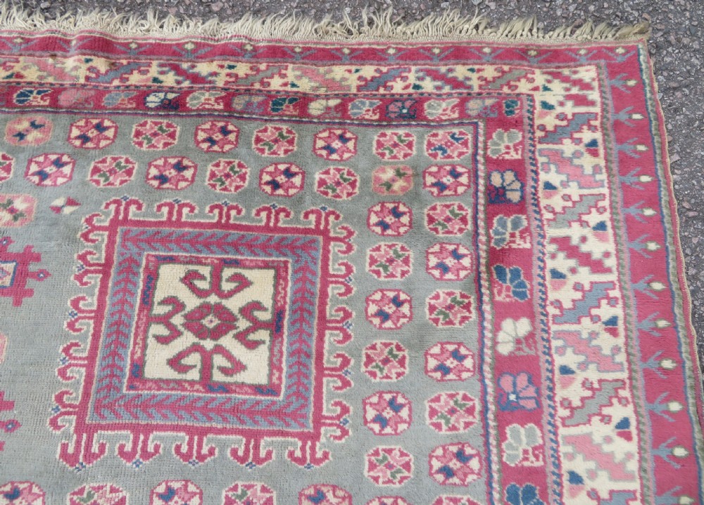 An antique Turkish Bergama wool carpet featuring a red central field surrounded by sage green areas with geometric Holbein square medallions and detailed borders. View VIII