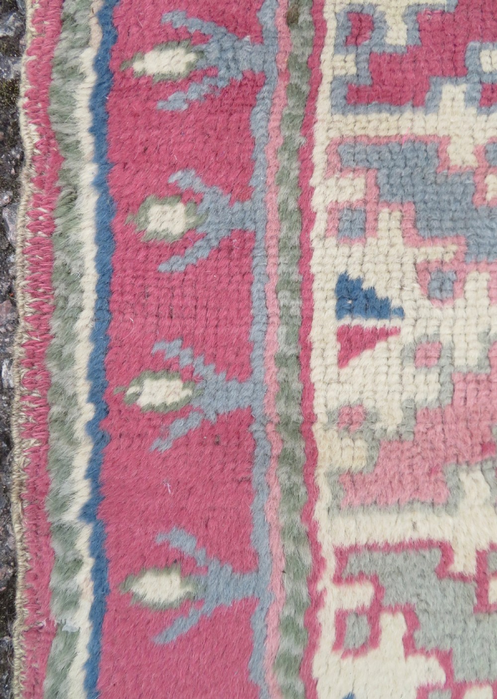 An antique Turkish Bergama wool carpet featuring a red central field surrounded by sage green areas with geometric Holbein square medallions and detailed borders. View X