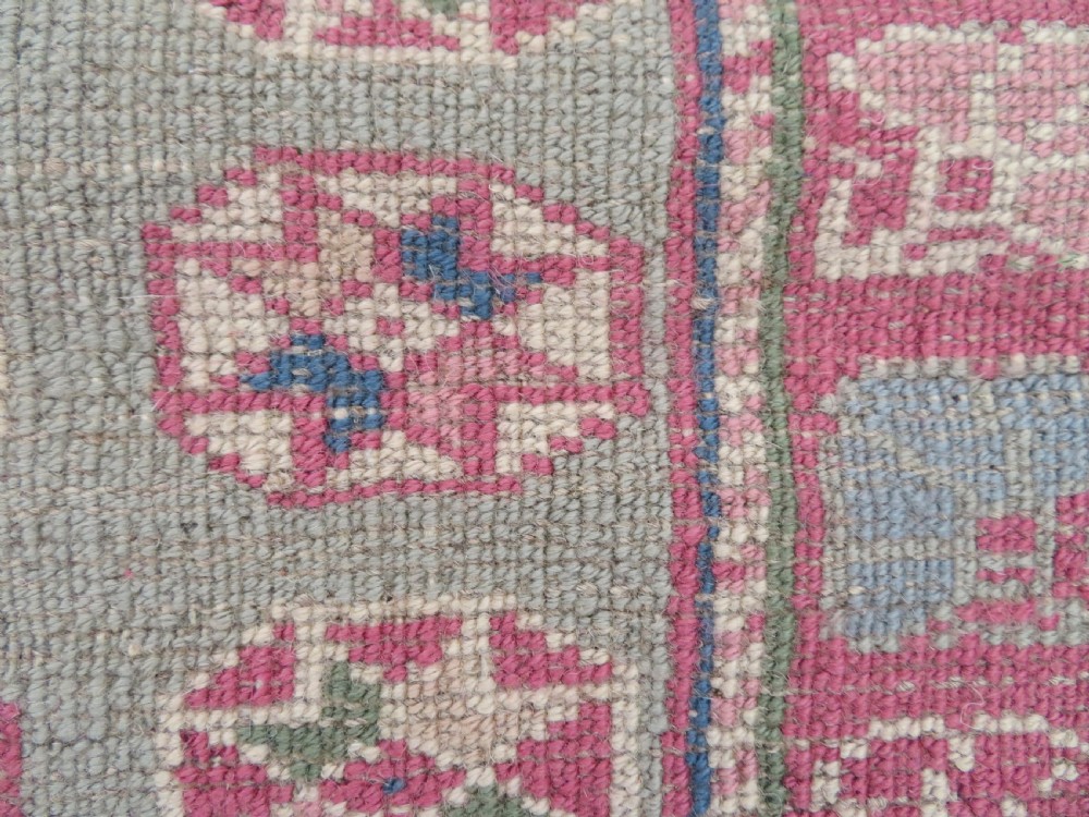 An antique Turkish Bergama wool carpet featuring a red central field surrounded by sage green areas with geometric Holbein square medallions and detailed borders. View XVI