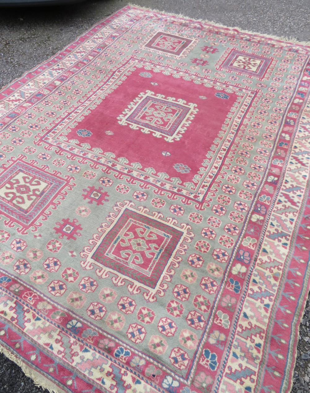 An antique Turkish Bergama wool carpet featuring a red central field surrounded by sage green areas with geometric Holbein square medallions and detailed borders. View XX