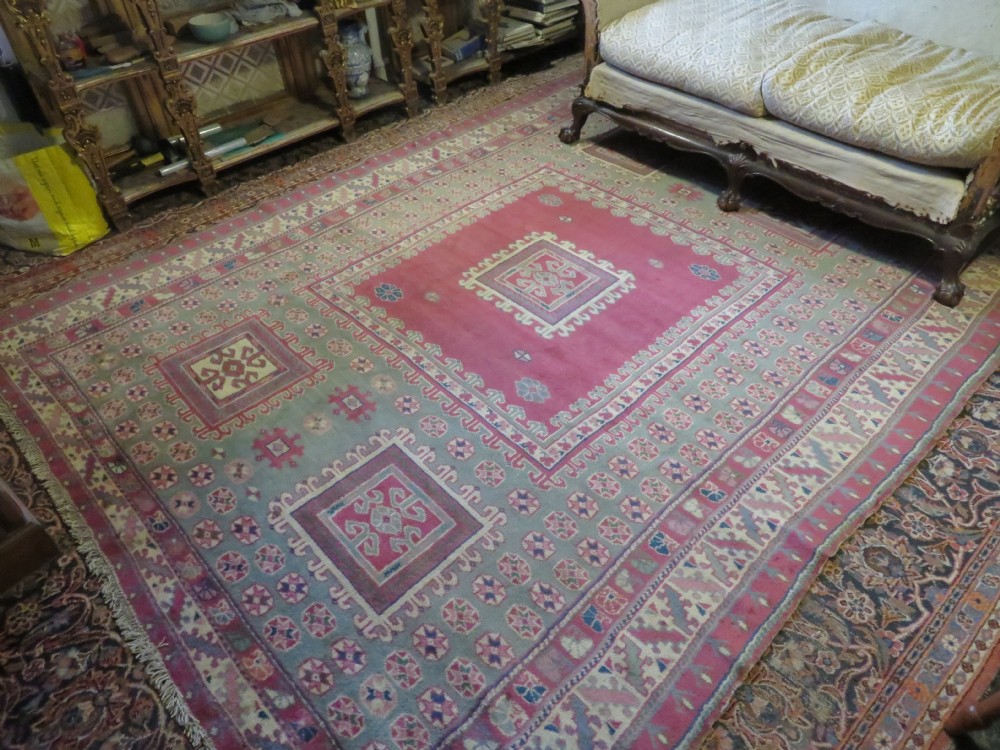 An antique Turkish Bergama wool carpet featuring a red central field surrounded by sage green areas with geometric Holbein square medallions and detailed borders. View XXVI
