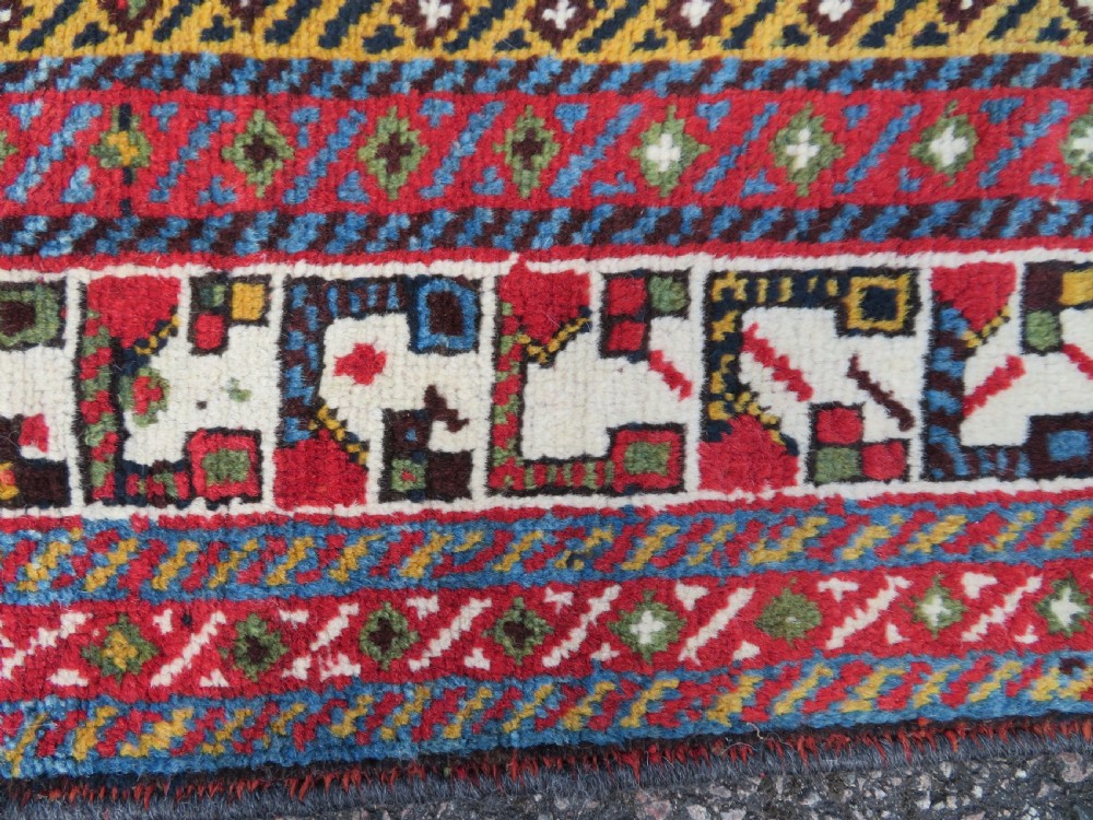 An antique hand-knotted Qashqai wool rug featuring a dark navy field densely filled with geometric tribal motifs and stylised figures within a multi-tiered border. View XIII