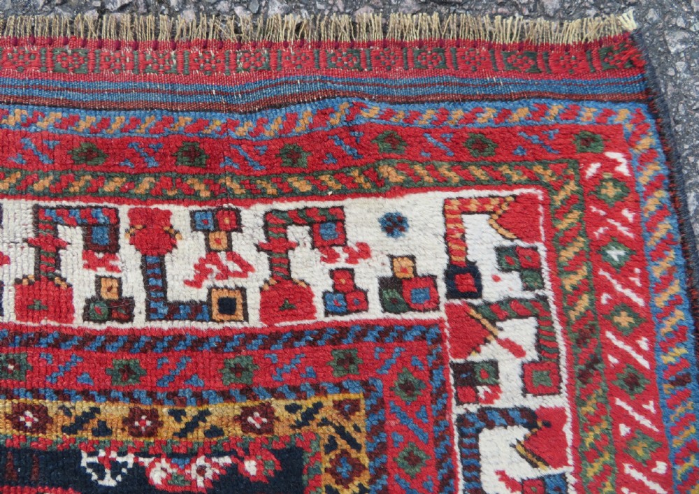 An antique hand-knotted Qashqai wool rug featuring a dark navy field densely filled with geometric tribal motifs and stylised figures within a multi-tiered border. View XIV