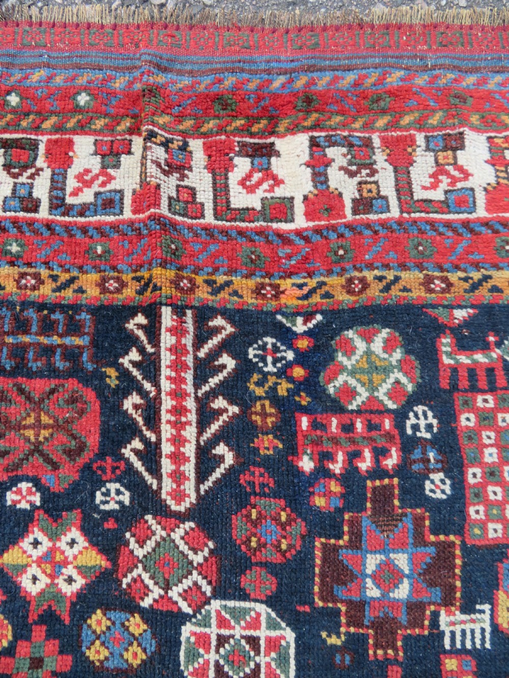 An antique hand-knotted Qashqai wool rug featuring a dark navy field densely filled with geometric tribal motifs and stylised figures within a multi-tiered border. View XVI