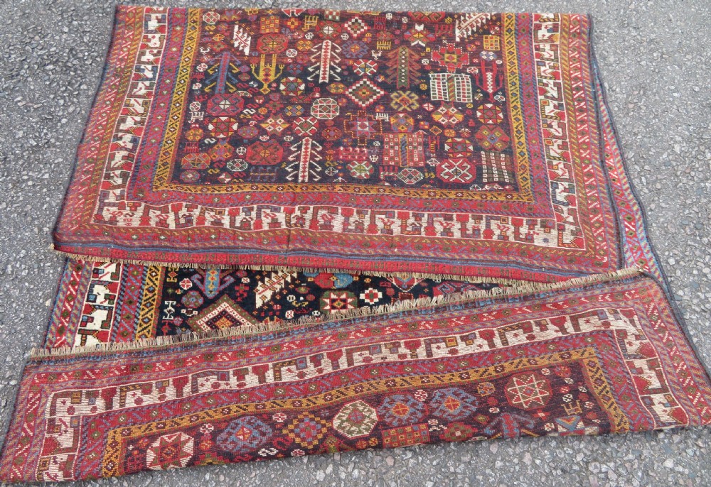 An antique hand-knotted Qashqai wool rug featuring a dark navy field densely filled with geometric tribal motifs and stylised figures within a multi-tiered border. View XXII