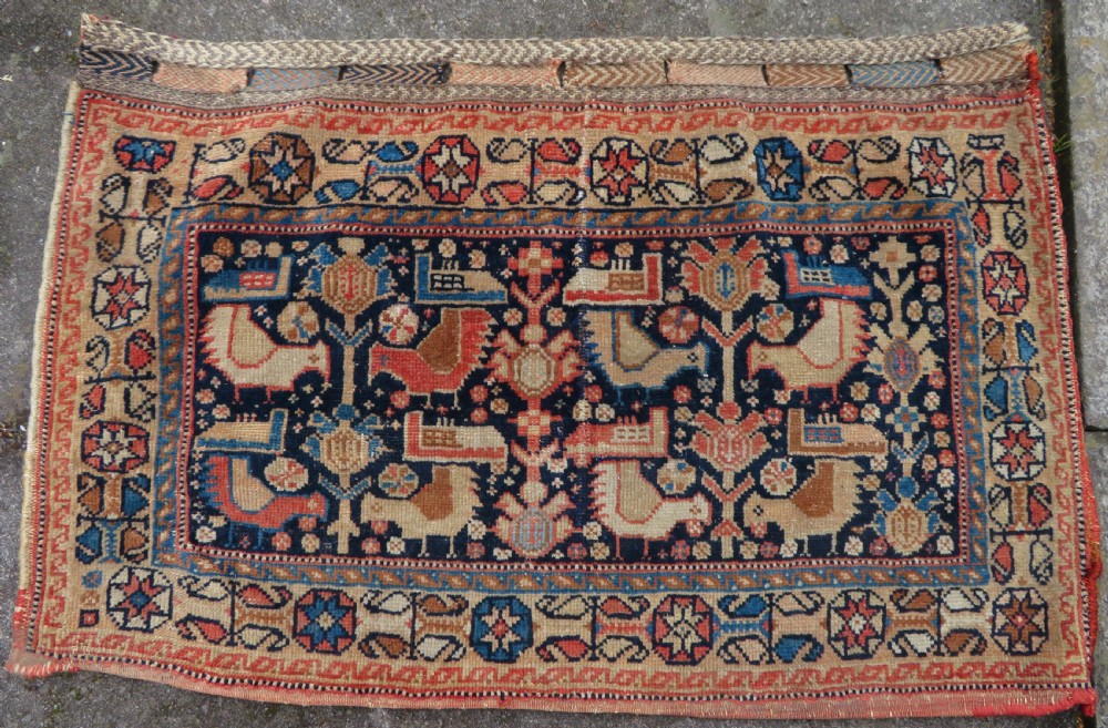 A 19th-century Khamseh hand-knotted wool bag face featuring stylised bird motifs framed by intricate geometric borders in navy blue, terracotta, and ochre.
