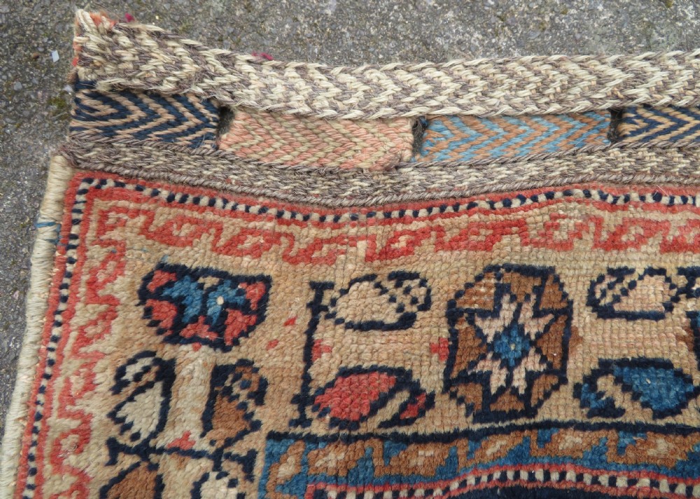 A 19th-century Khamseh hand-knotted wool bag face featuring stylised bird motifs framed by intricate geometric borders in navy blue, terracotta, and ochre. View X
