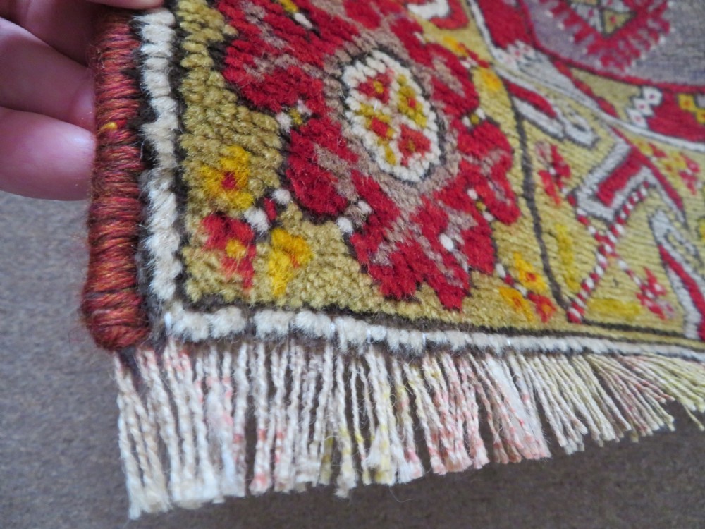 An early 19th-century Central Anatolian Konya rug featuring a central red field with a stepped diamond medallion surrounded by mustard-yellow geometric borders. View XIV