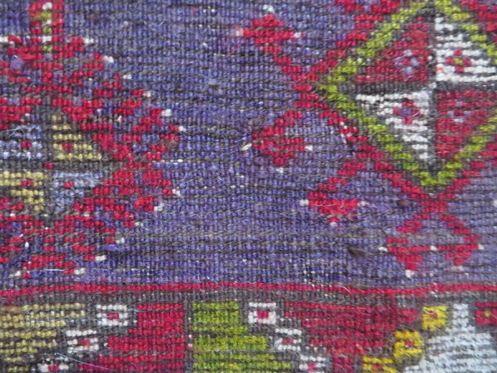 An early 19th-century Central Anatolian Konya rug featuring a central red field with a stepped diamond medallion surrounded by mustard-yellow geometric borders. View XVII