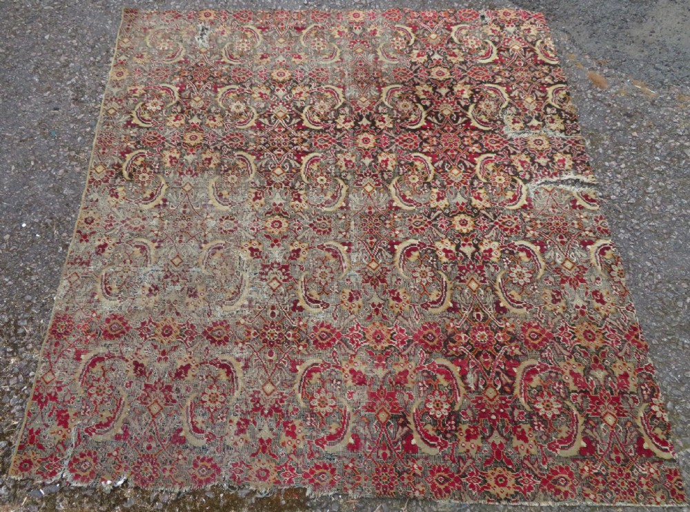 A square-shaped North Indian Mughal wool carpet fragment featuring detailed crimson and dark brown floral scrollwork. View II