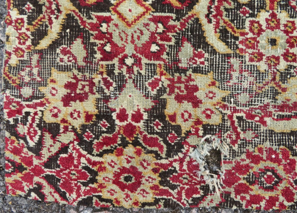 A square-shaped North Indian Mughal wool carpet fragment featuring detailed crimson and dark brown floral scrollwork. View VII