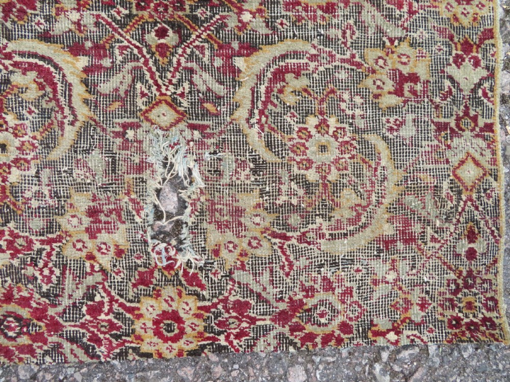 A square-shaped North Indian Mughal wool carpet fragment featuring detailed crimson and dark brown floral scrollwork. View VIII