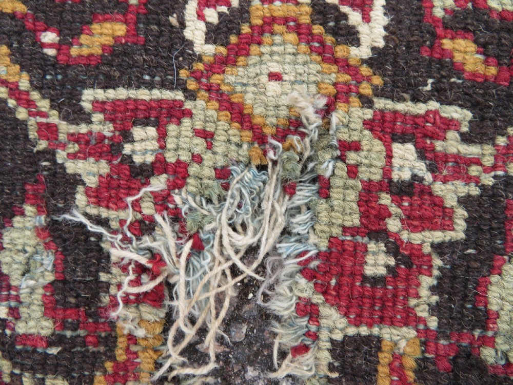 A square-shaped North Indian Mughal wool carpet fragment featuring detailed crimson and dark brown floral scrollwork. View XIV