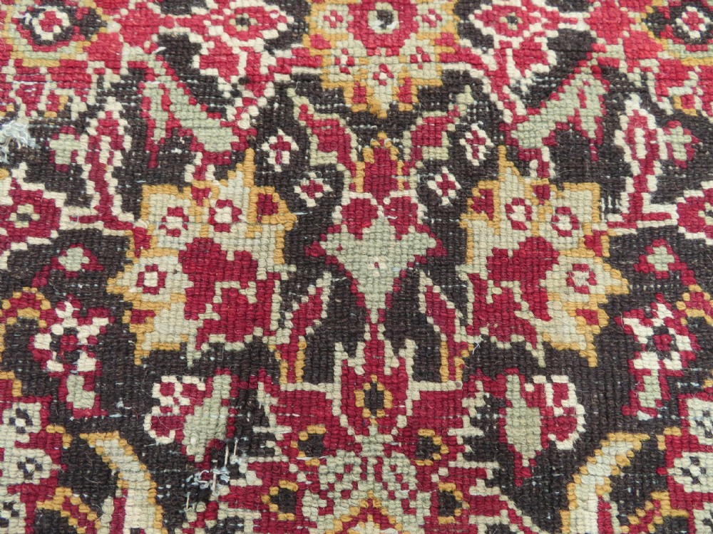 A square-shaped North Indian Mughal wool carpet fragment featuring detailed crimson and dark brown floral scrollwork. View XVI