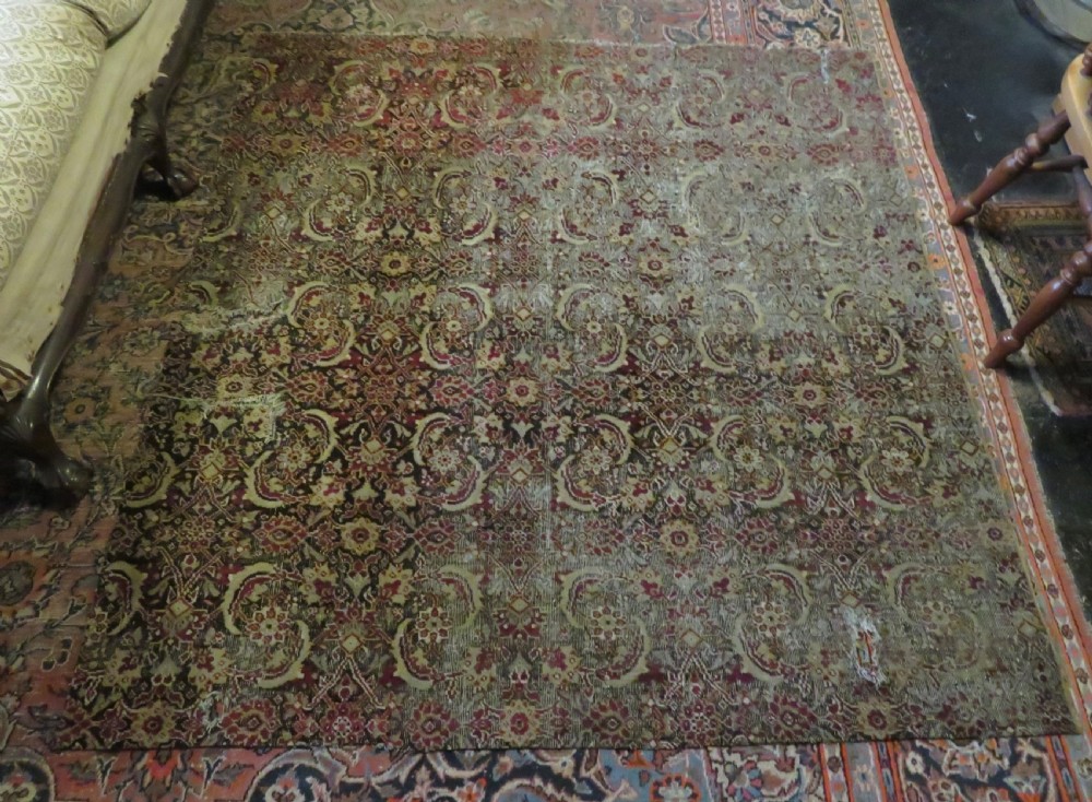 A square-shaped North Indian Mughal wool carpet fragment featuring detailed crimson and dark brown floral scrollwork. View XVII