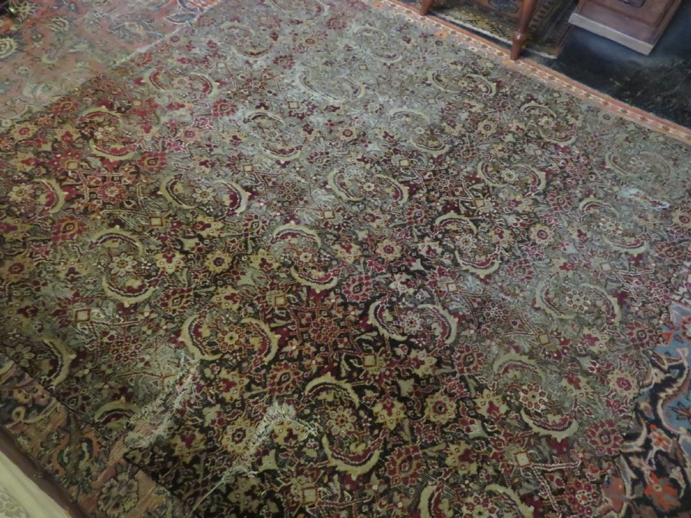 A square-shaped North Indian Mughal wool carpet fragment featuring detailed crimson and dark brown floral scrollwork. View XVIII