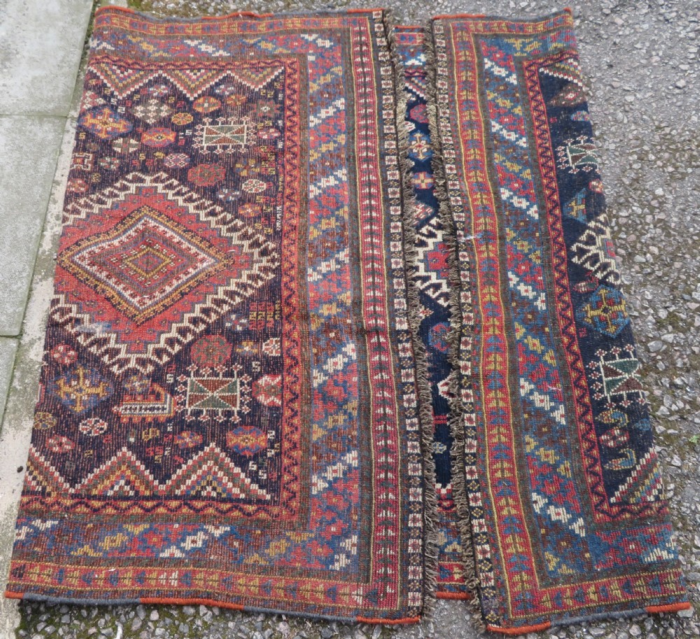 An antique hand-knotted Luri wool rug featuring three central diamond medallions surrounded by geometric tribal symbols on a dark navy field with a red border. View XII