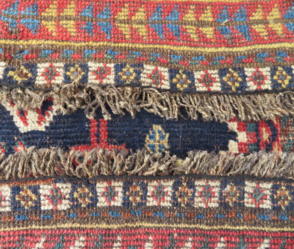 An antique hand-knotted Luri wool rug featuring three central diamond medallions surrounded by geometric tribal symbols on a dark navy field with a red border. View XIII