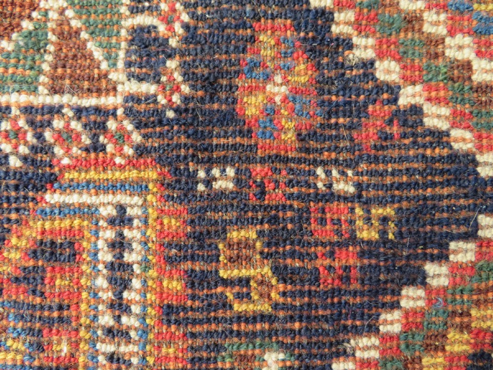 An antique hand-knotted Luri wool rug featuring three central diamond medallions surrounded by geometric tribal symbols on a dark navy field with a red border. View XIV