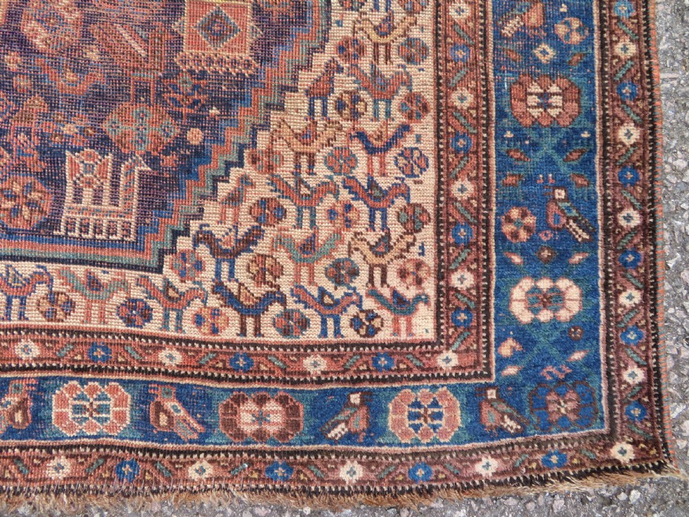 A hand-knotted antique Khamseh wool rug featuring three stepped diamond medallions surrounded by dense floral and avian tribal motifs on a dark navy blue field with multi-tiered geometric borders. View VIII