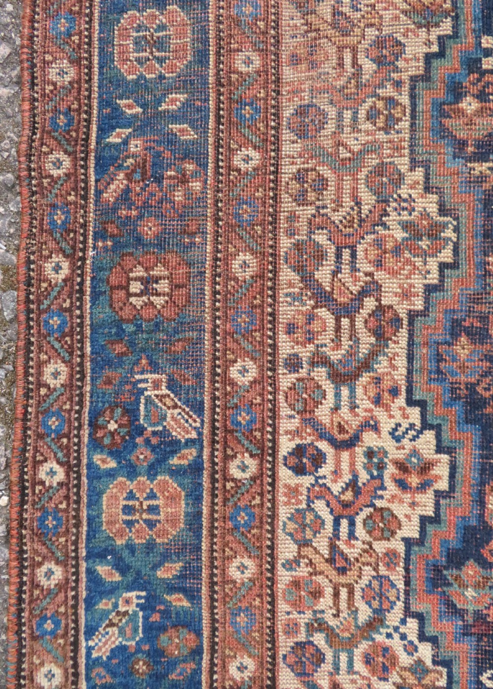A hand-knotted antique Khamseh wool rug featuring three stepped diamond medallions surrounded by dense floral and avian tribal motifs on a dark navy blue field with multi-tiered geometric borders. View IX