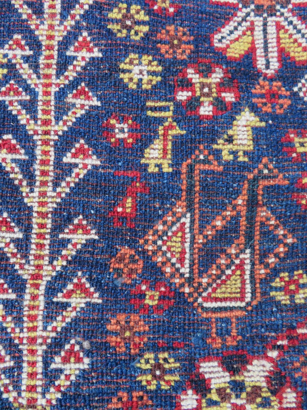 An antique Qashqai tribal wool rug featuring a deep blue central field with geometric bird motifs, red spandrels, and a complex multi-band border. View XIV