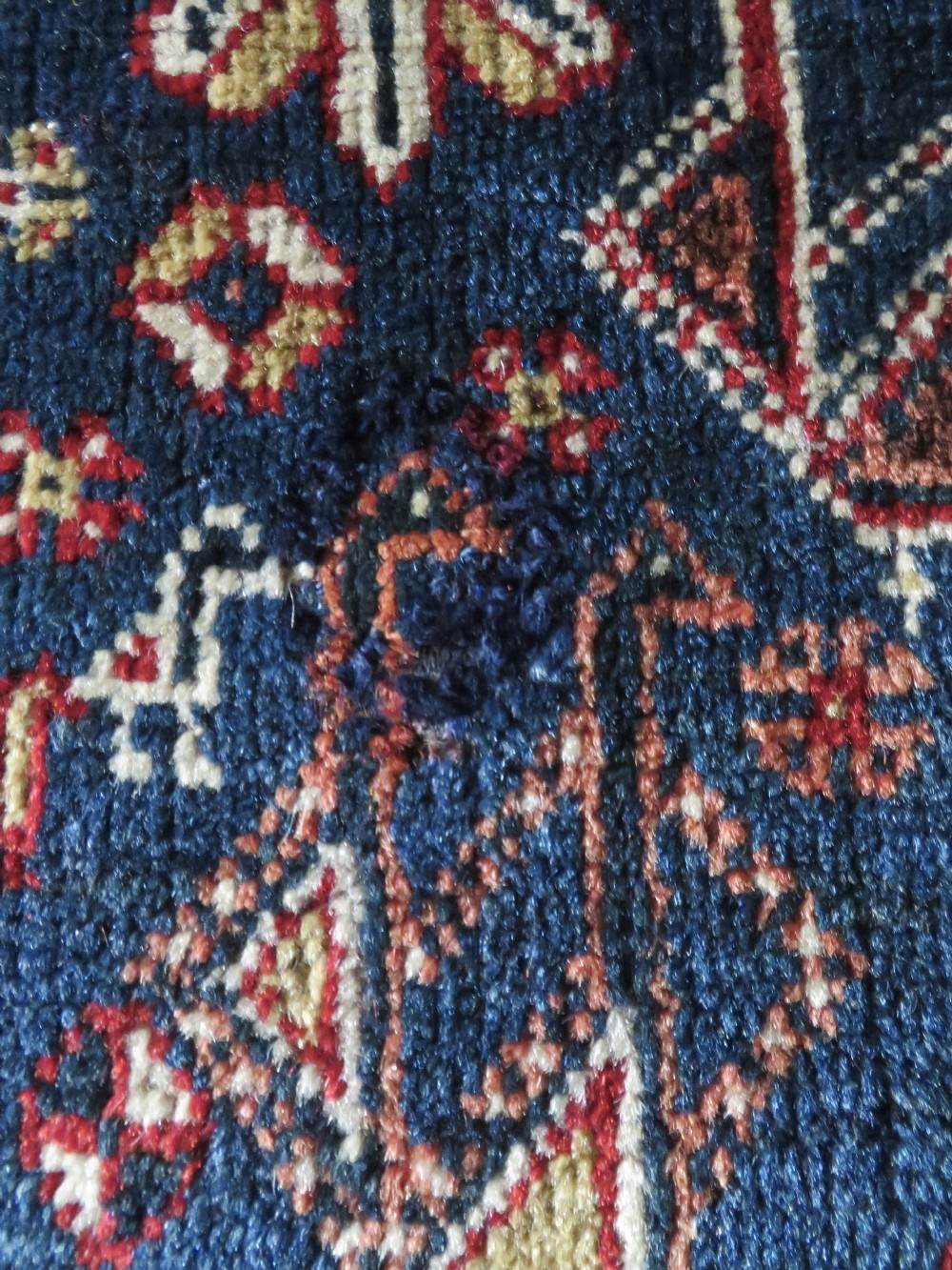 An antique Qashqai tribal wool rug featuring a deep blue central field with geometric bird motifs, red spandrels, and a complex multi-band border. View IX