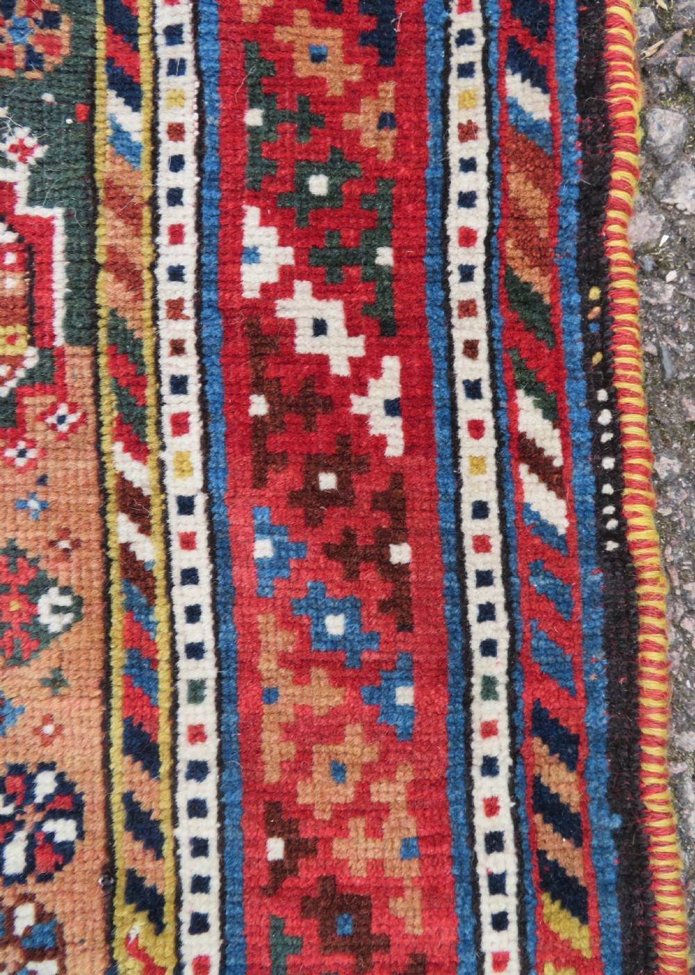 An antique hand-knotted Luri tribal rug featuring central diamond medallions on an indigo blue field framed by geometric red borders. View IX