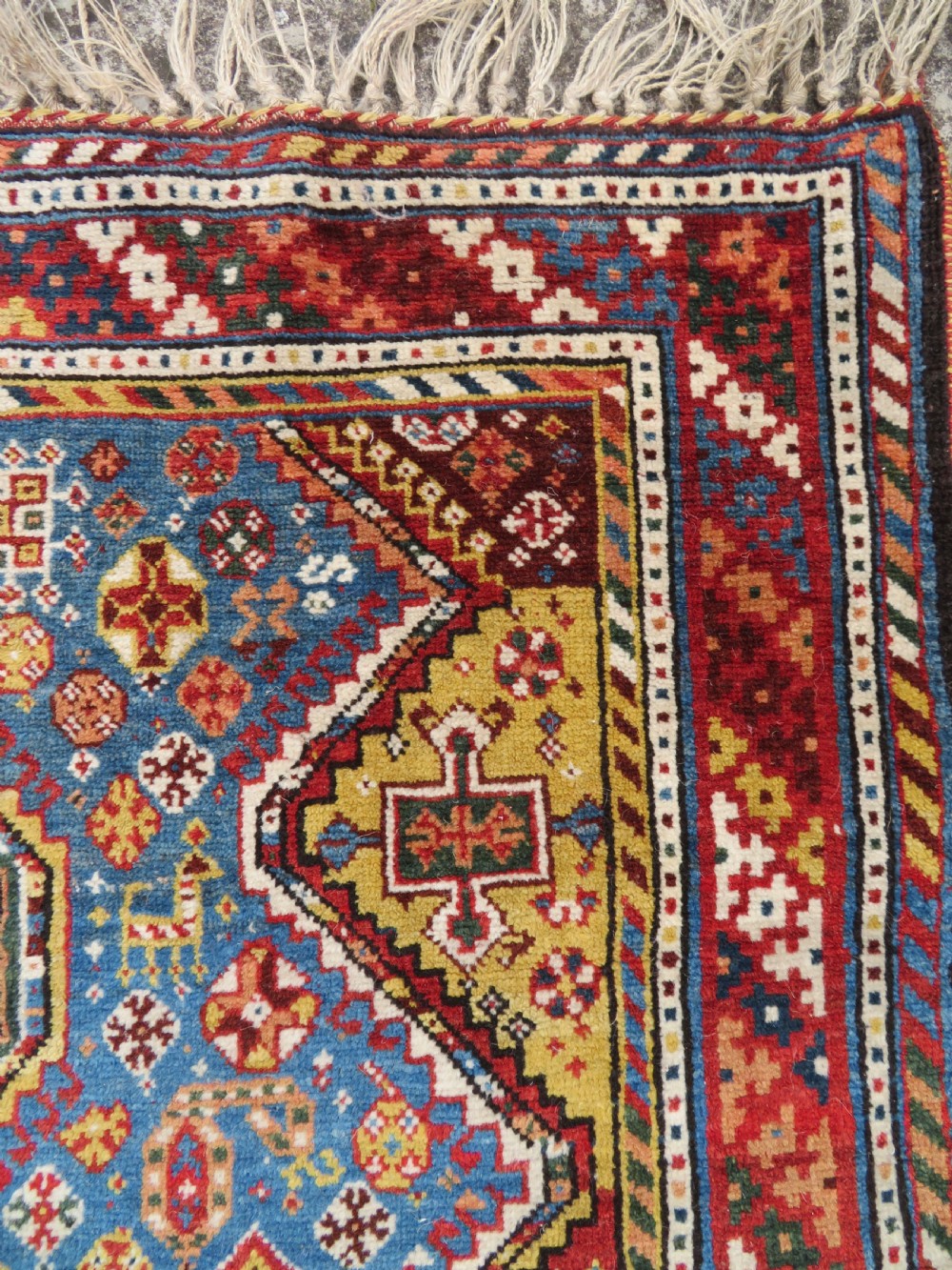An antique hand-knotted Luri tribal rug featuring central diamond medallions on an indigo blue field framed by geometric red borders. View XII