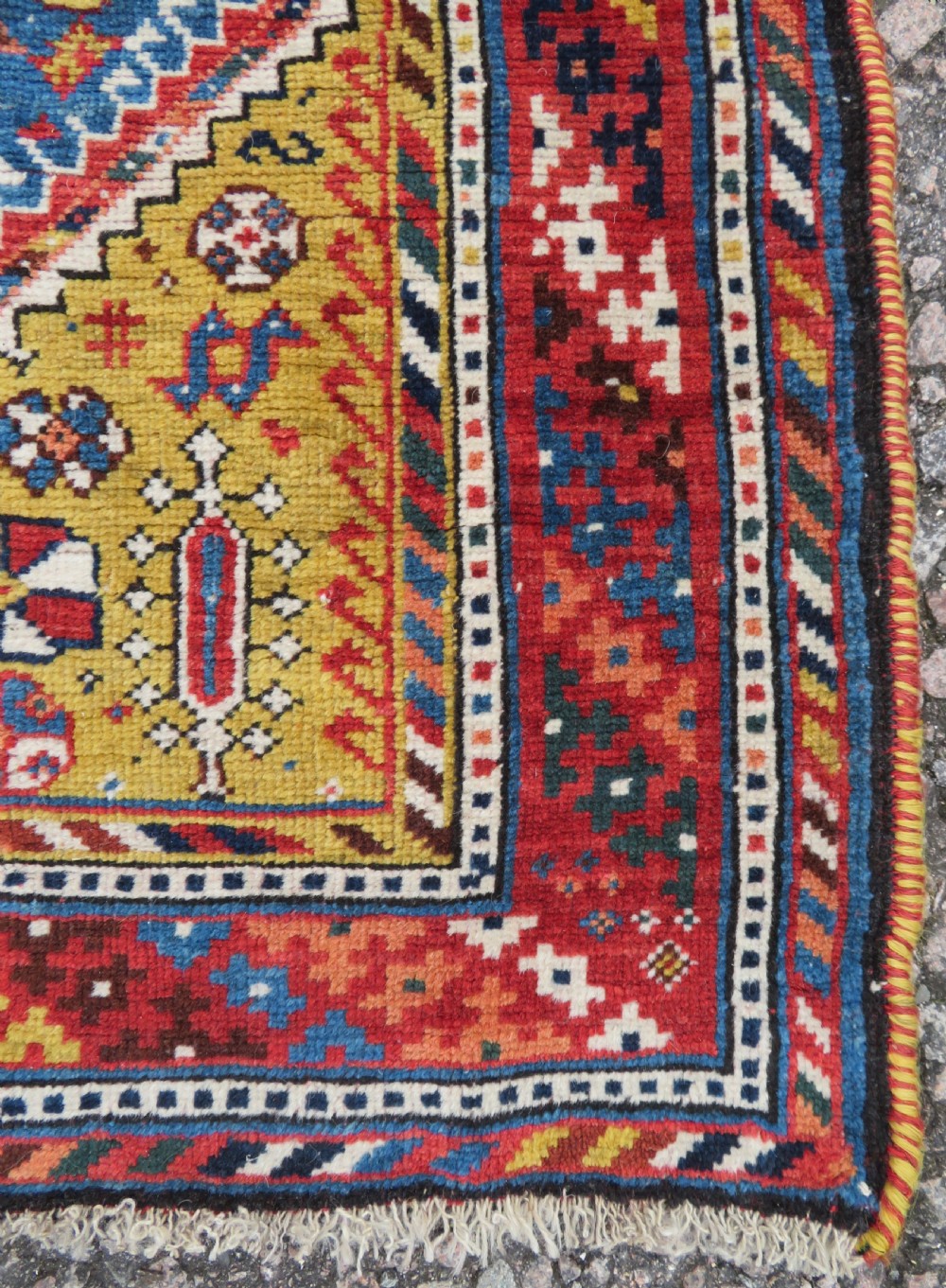 An antique hand-knotted Luri tribal rug featuring central diamond medallions on an indigo blue field framed by geometric red borders. View XVII