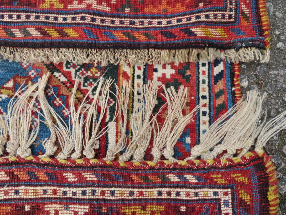 An antique hand-knotted Luri tribal rug featuring central diamond medallions on an indigo blue field framed by geometric red borders. View XXIII