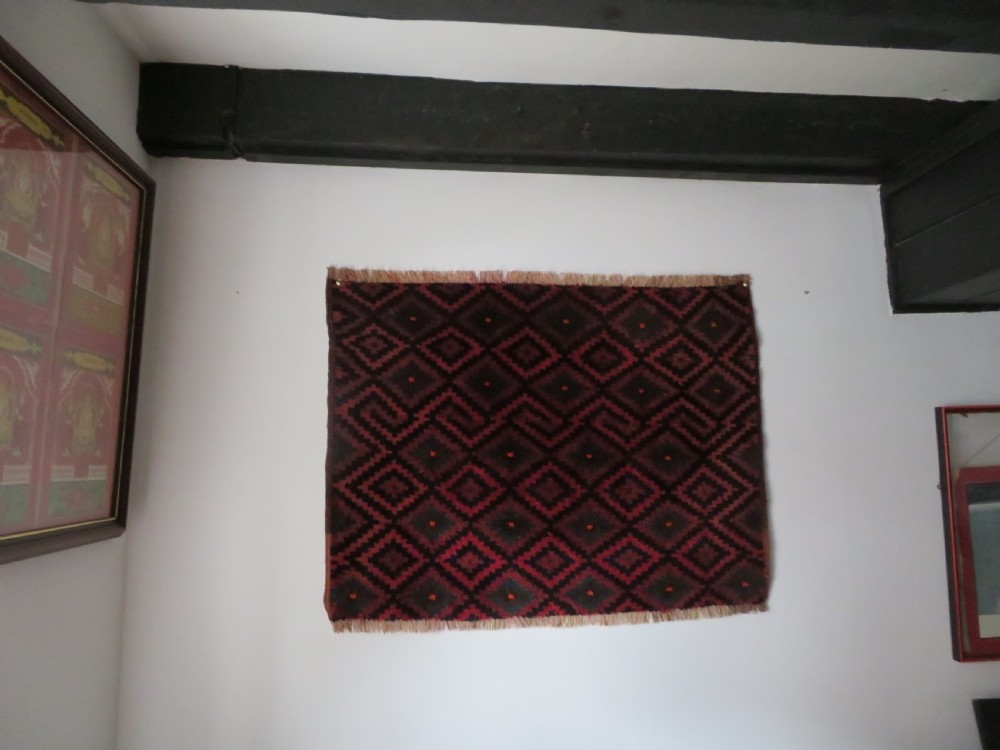 An antique hand-woven Luri saddle bag face featuring a repeating geometric diamond lattice pattern in shades of red, dark blue, cyan, and orange with fringed edges. View IV