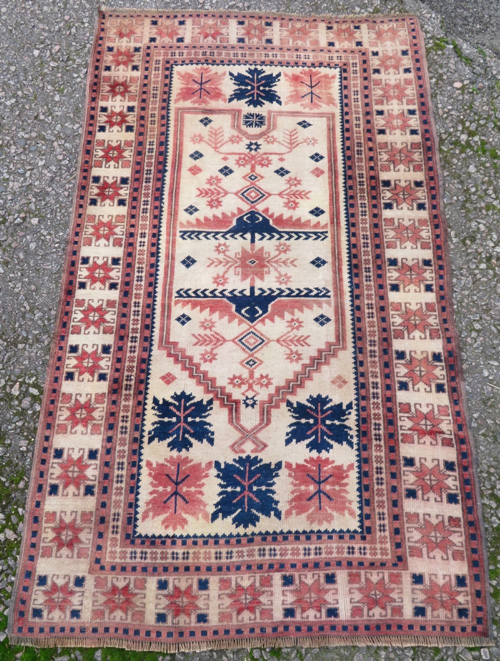 A hand-knotted wool Anatolian Bergama prayer rug featuring an ivory central field with a geometric arched mihrab design framed by terracotta and navy blue geometric borders. View IV