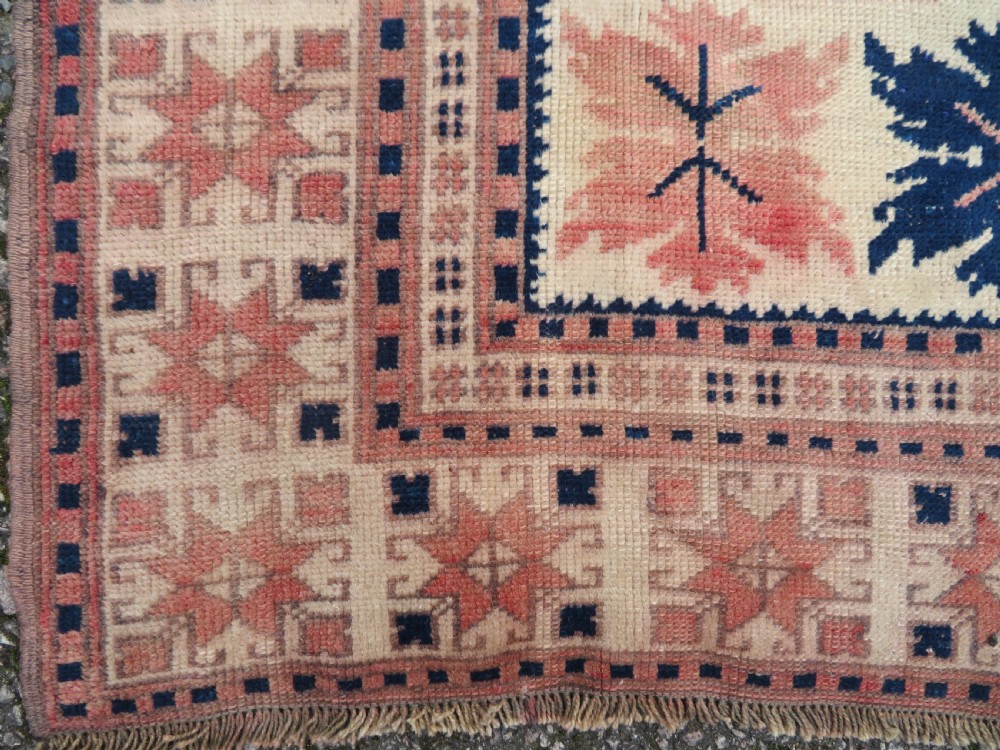 A hand-knotted wool Anatolian Bergama prayer rug featuring an ivory central field with a geometric arched mihrab design framed by terracotta and navy blue geometric borders. View VII