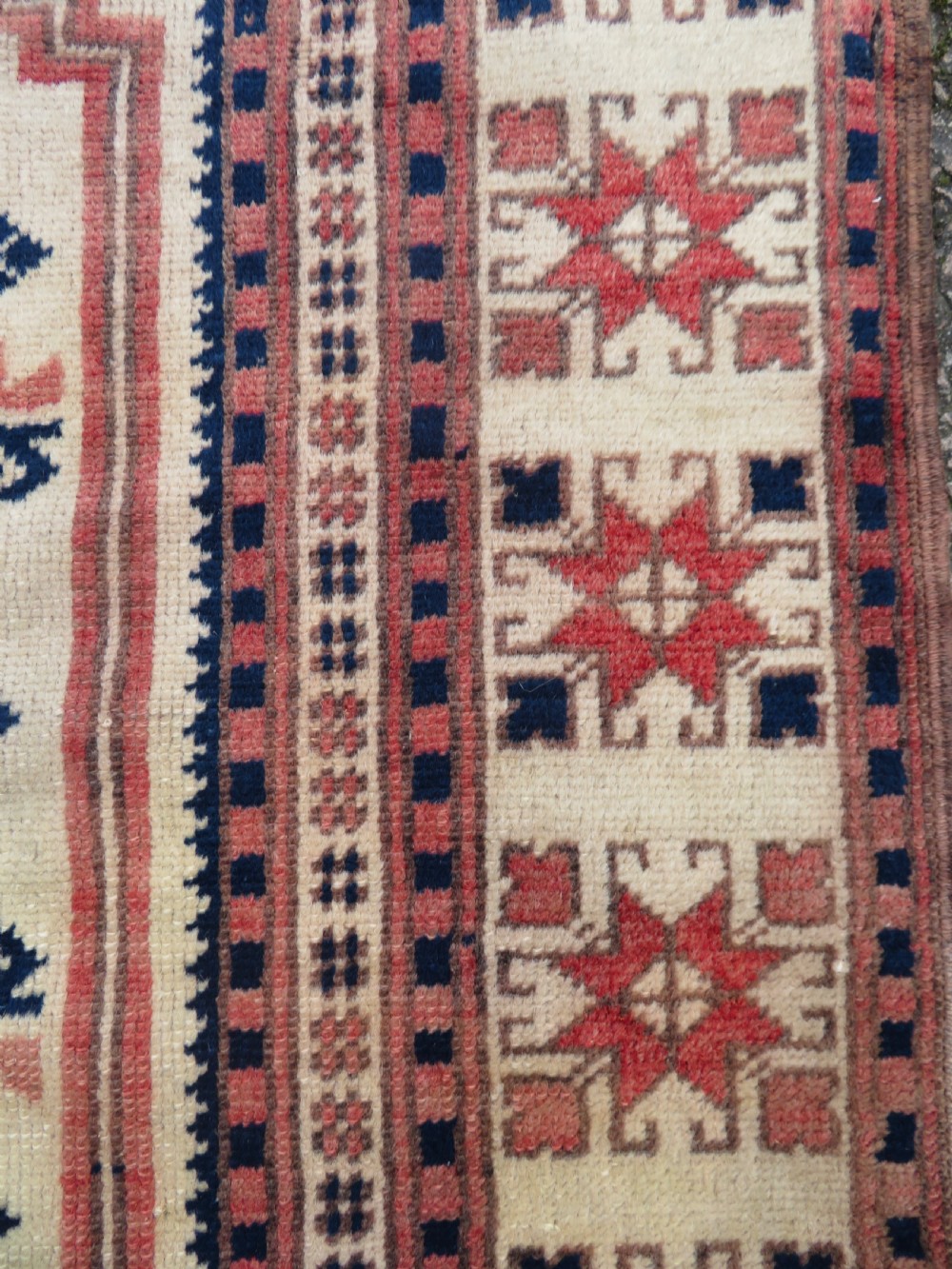 A hand-knotted wool Anatolian Bergama prayer rug featuring an ivory central field with a geometric arched mihrab design framed by terracotta and navy blue geometric borders. View VIII