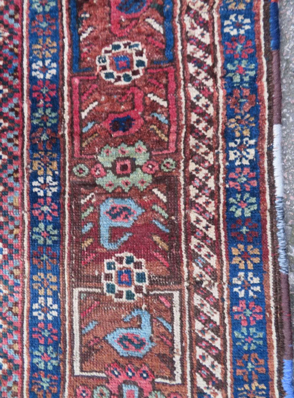An antique Persian Khamseh rug featuring three central diamond medallions surrounded by small animal motifs and a geometric border in indigo blue and terracotta red tones. View VIII