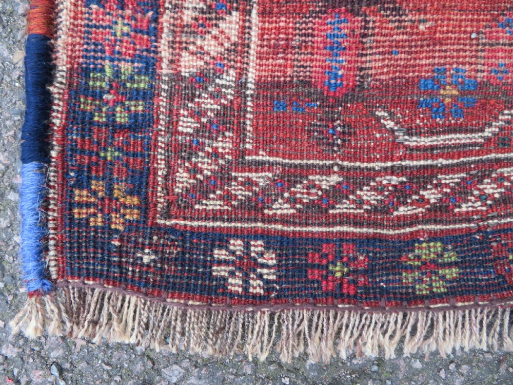 An antique Persian Khamseh rug featuring three central diamond medallions surrounded by small animal motifs and a geometric border in indigo blue and terracotta red tones. View XII