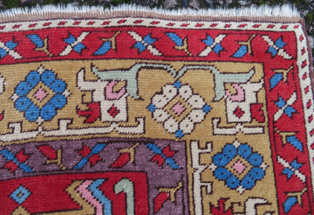 A mid-19th-century hand-knotted Turkish Ladik prayer rug featuring a blue central niche on a red ground with inverted tulip motifs and a patterned yellow border. View VI
