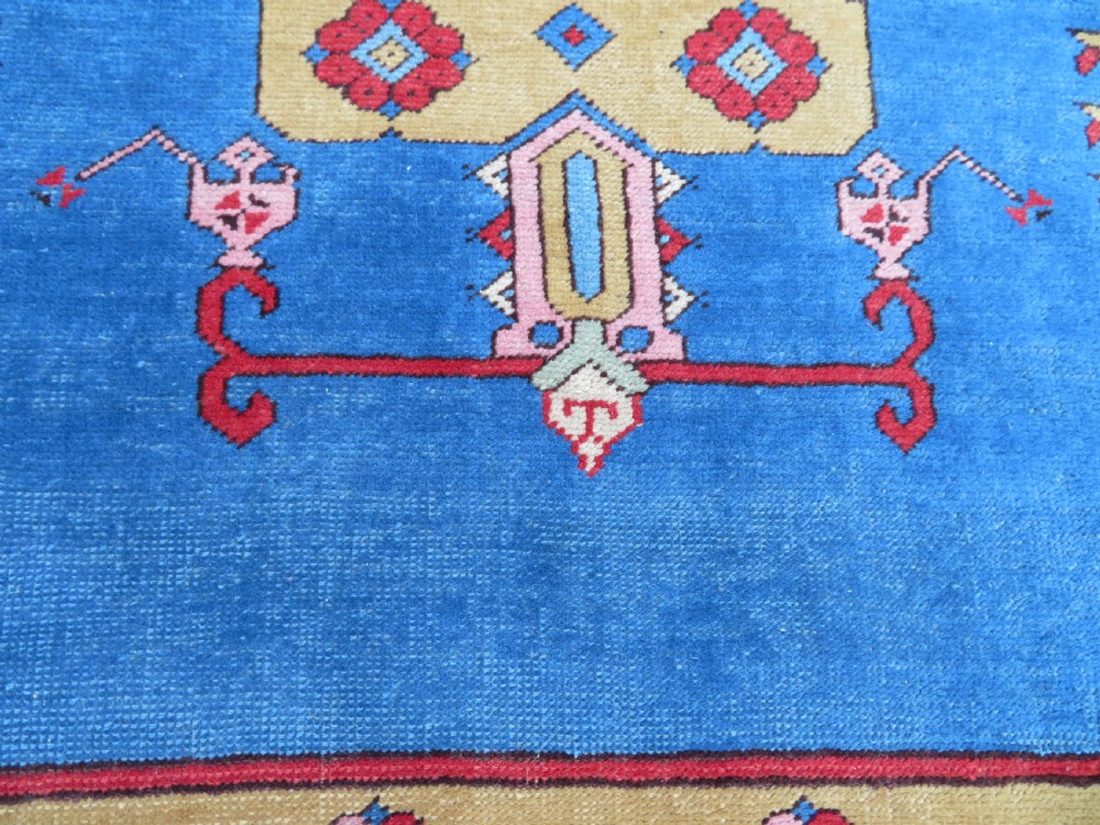 A mid-19th-century hand-knotted Turkish Ladik prayer rug featuring a blue central niche on a red ground with inverted tulip motifs and a patterned yellow border. View VIII
