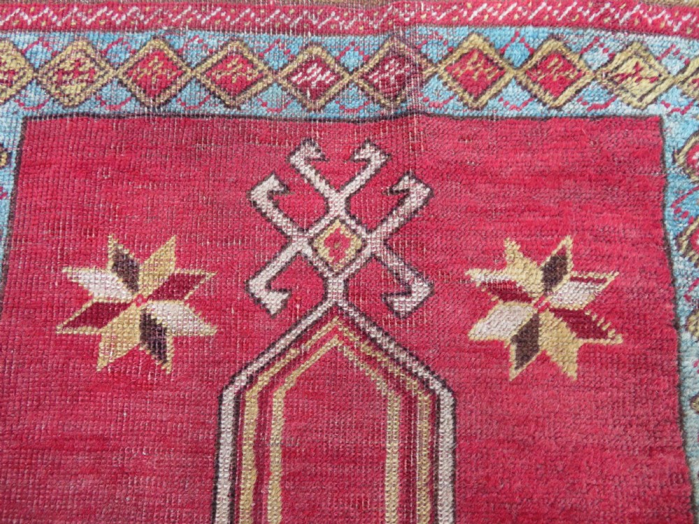 A mid-19th-century hand-knotted Turkish Mudjur prayer rug with a red central mihrab niche framed by geometric floral patterned borders. View III