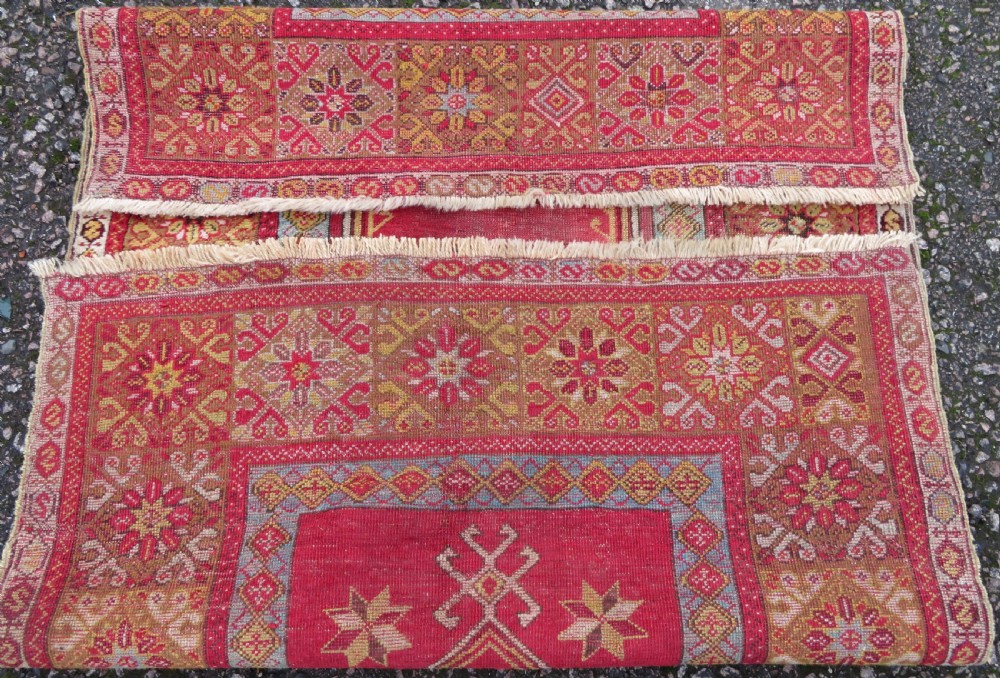 A mid-19th-century hand-knotted Turkish Mudjur prayer rug with a red central mihrab niche framed by geometric floral patterned borders. View IX