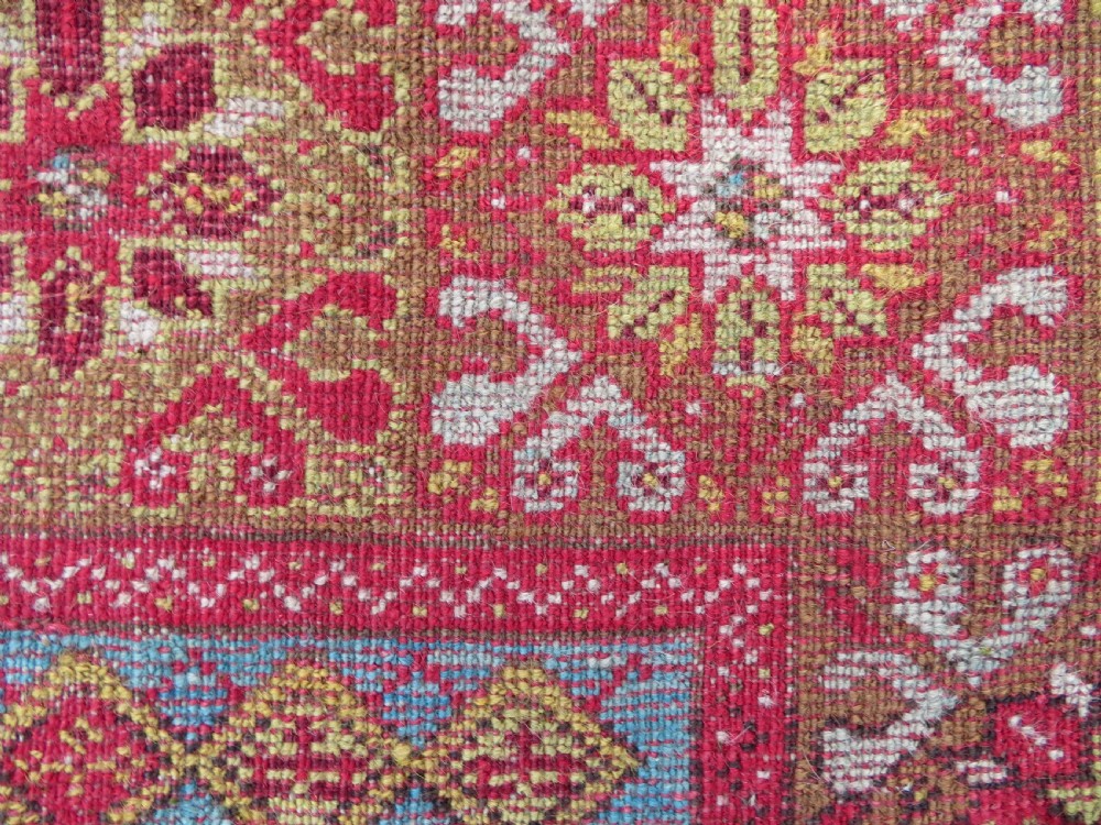 A mid-19th-century hand-knotted Turkish Mudjur prayer rug with a red central mihrab niche framed by geometric floral patterned borders. View XI