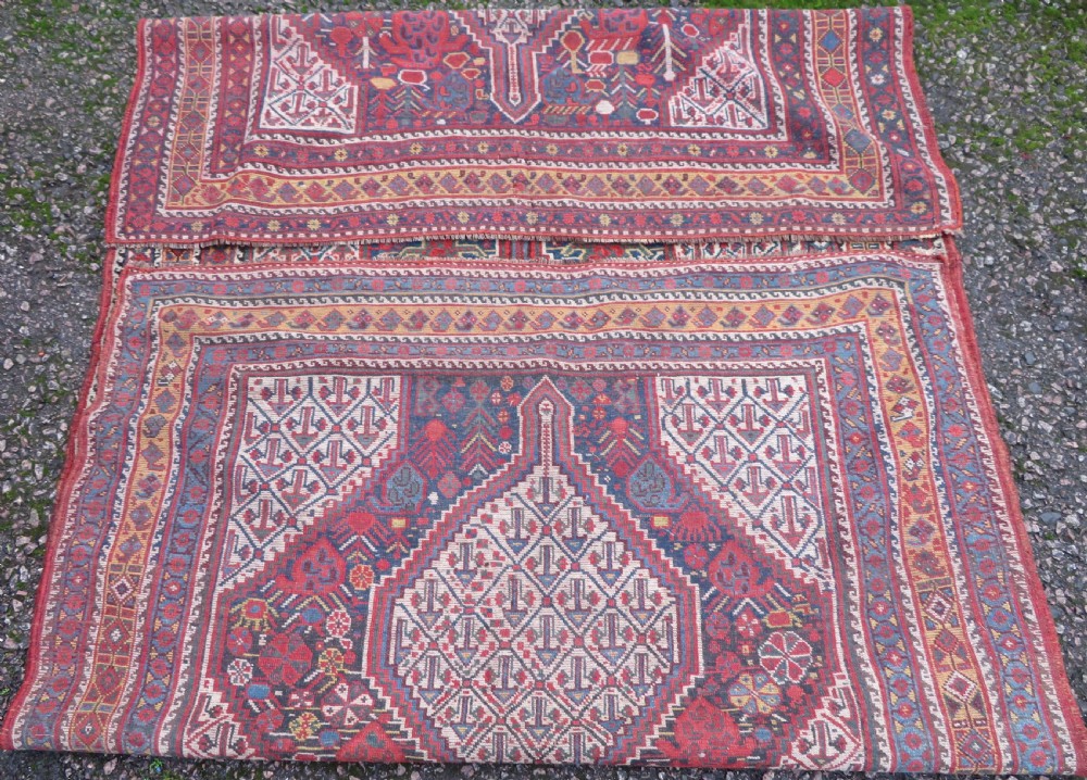 An antique Khamseh Basseri hand-knotted wool rug featuring geometric diamond medallions in red, blue, and ivory tones. View XVI