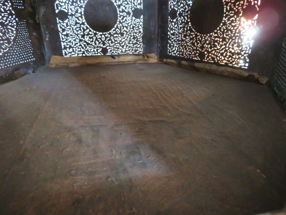 An octagonal Cairo ware brass kursi table with silver and copper inlay, Arabic calligraphy, pierced fretwork panels, and small cupboard doors on turned legs. View VII