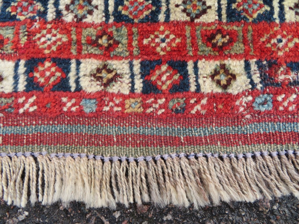 An antique hand-knotted Khamseh tribal rug featuring two diamond medallions on an ivory field filled with bird and geometric motifs, surrounded by a red patterned border. View XIV
