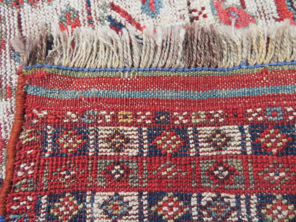 An antique hand-knotted Khamseh tribal rug featuring two diamond medallions on an ivory field filled with bird and geometric motifs, surrounded by a red patterned border. View XVIII