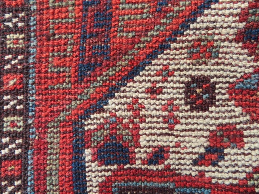 An antique hand-knotted Khamseh tribal rug featuring two diamond medallions on an ivory field filled with bird and geometric motifs, surrounded by a red patterned border. View XIX