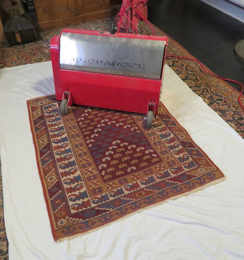 A small antique Turkish Bergama wool rug featuring a deep red central field with repeating floral-like motifs surrounded by geometric cream and blue borders. View IX