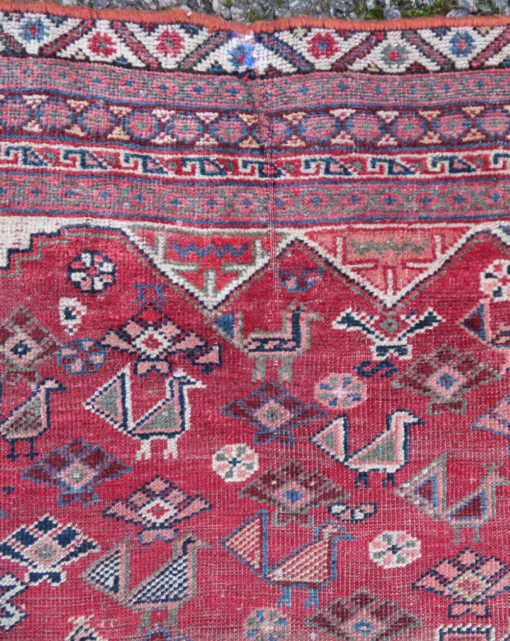 An antique hand-knotted Khamseh tribal kelleh carpet with a dark red field, geometric diamond medallions, and small bird motifs. View XVII